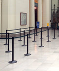 Commercial-Grade Stanchion Set 2-Pack With 10 Ft Retractable Belt Barrier Heavy Base Crowd Control Poles in a queue setup