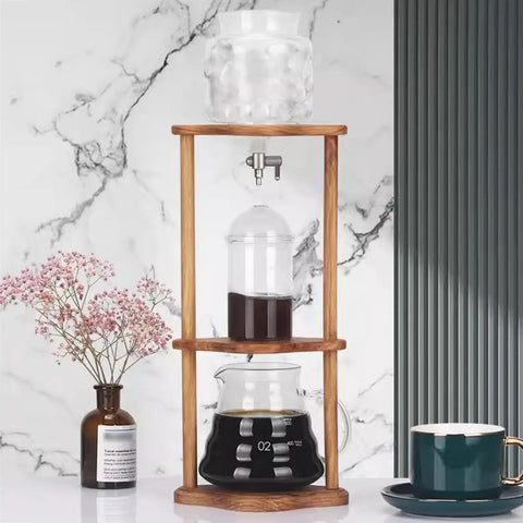 Portable Cold Brew Drip Tower And Adjustable Iced Coffee Maker Featuring Removable Filter For Smooth Extraction with wood frame and glass jug.