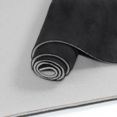 Close-up view of rolled black suede headliner fabric with foam backing.
