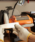 Heavy Duty Bench Grinder And Belt Sander Combo Featuring A Rock Solid 8 Inch Grinding Wheel With A Killer 2x28 Belt Sander Powered By A Smooth Running 2.5 Amp Induction Motor Built Tough For Metalworking Sharpening And Shop Projects in use sharpening a kitchen knife.