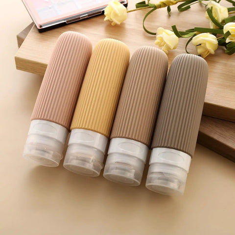 TSA Approved Travel Bottles Set Three Ounce Silicone Squeeze Containers Leak Proof BPA Free, four bottles on a wooden surface