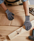 Person wearing micro foam nitrile coated work gloves with seamless knit nylon for gripping a wooden plank, 32 pairs pack.