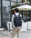 Person wearing DSLR Camera Backpack With Shockproof Shell outdoors, showcasing cushioned straps and sleek design for photography.