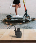 Rust Proof Metal Electric Scooter Stem Folding Lever For F30 Handlebar Fold Mechanism next to a scooter in motion