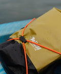 ExoDry 20L Dry Bag With Roll Top Closure on kayak, waterproof gear carrier, orange straps, black and tan color