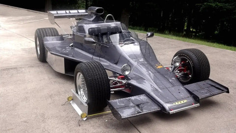 Heavy Duty 2 Wheel Alignment Tool For Camber Caster And Toe with precision standoffs beside a sleek racing car.