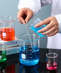 Person using Borosilicate Glass Beaker Set With Stirring Rod For Lab Chemistry 4 Sizes 50 Milliliters 100 Milliliters 250 Milliliters 500 Milliliters Thick Durable Glassware For Science Experiments And Lab Supplies Must Have with colored liquids.