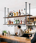 Industrial Dope Two Tier Ceiling Mount Wine Rack With Glass Holders in a bar setting, showcasing iron and wood design.