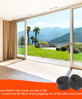 Four Piece Barn Door Stopper Set with black anti jump pads installed on sliding door track in a bright room with mountain view.