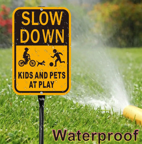 Slow Down Kids At Play Safety Signs in yellow and black reflective aluminum on grass with water spray illustration
