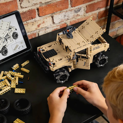 Technic RC Hummer kit being assembled on a table with instructions on a tablet, demonstrating hands-on STEM learning and creativity.