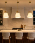 Karjearl Gold Pendant Lights Kitchen Island, 12.2" Linen Drum Chandelier above a modern kitchen island with stools.