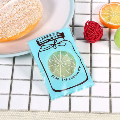 Set of 100 Cute Plastic Candy Bags With Clear Window and Bottle Pattern, blue bag on tiled surface with fruit decor