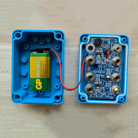 Open view of Fencing Gear Diagnostic Tool With Color-Coded Slots and Indicator Lights for blade testing, shows internal components.