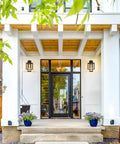 Outdoor Wall Sconce 2-Pack Farmhouse Exterior Lanterns in Black Finish With Bubble Glass Shades on modern porch.