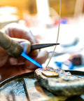 Focusing on the Top Tier Copper Welding Rods Kit 4pcs for Jewelry Making, a welder using a torch to solder metal.