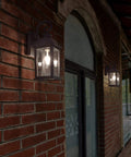 Dusk To Dawn Outdoor Wall Light With Sensor, Waterproof Matte Black Porch Sconce illuminating a brick wall exterior with glass lantern.