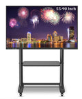 Heavy Duty Rolling TV Cart For 55 To 90 Inch Screens With Lockable Rubber Wheels and Slick Laptop Camera Shelf in use with a vibrant city skyline.