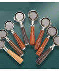 Various 58mm bottomless portafilters with wooden handles for espresso preparation and brewing techniques.