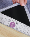 Hand lifting corner of a rug to show Four Pack Non Slip Rug Pads For Hardwood Floors And Tile Grippers That Keep Rugs In Place.