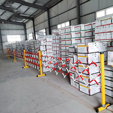 Tough As Nails Traffic Barricade Heavy Duty Industrial Crowd Control Barrier For Construction Zones And Large Gatherings Uv Resistant FRP Expandable Safety Fence Red White securing boxes in a warehouse.
