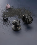 Black Interior Door Knobs Set Non Locking Privacy Hall Door Handle Vintage Vibe Lever With Smooth Edge And Easy Grip For Bedroom And Bathroom Doors Built To Last; Product displayed on scattered black particles with a dark background.