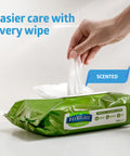 Hand pulling Aloe Infused Adult Incontinence Cleansing Wipes, Large 8x10 Inches from green pack, No Rinse Formula shown
