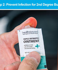 Close-up of Health & Beyond triple antibiotic ointment packet held in a hand.
