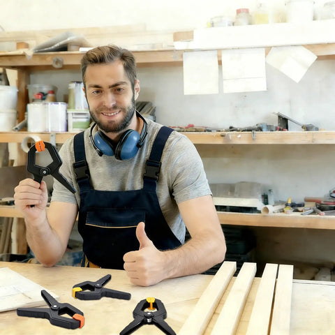 Man in workshop holding 10 Pack Heavy Duty Spring Clamps For Woodworking And DIY Projects Tough Nylon Frame With Steel Spring