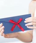 Person holding Retro Invitation Envelopes Set, 10 Pack, 22x11cm, 250gsm Kraft Paper Envelopes with red ribbon