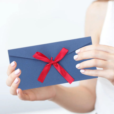 Person holding Retro Invitation Envelopes Set, 10 Pack, 22x11cm, 250gsm Kraft Paper Envelopes with red ribbon