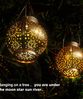 Outdoor Solar Lanterns 2 Pack Waterproof Hanging LED Lights With Metal Star Moon Sun Pattern illuminating a tree at night