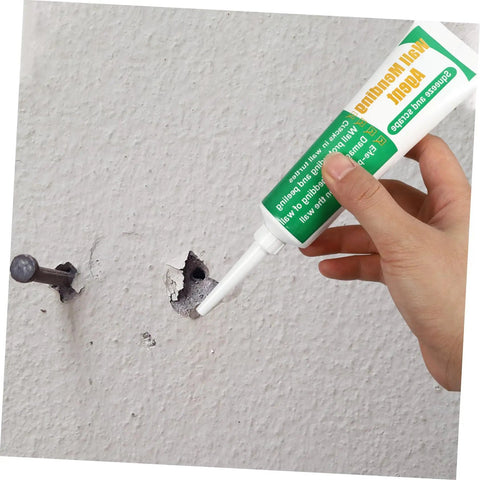 Person applying Two Set Wall Mending Repair Cream For Cracks Graffiti And Stains Easy To Apply Crack Paste to a wall hole.