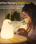 Squishy Duck Night Light For Kids With Soft Warm Glow Silicone Dimmable Nursery Lamp on table near mother and baby.