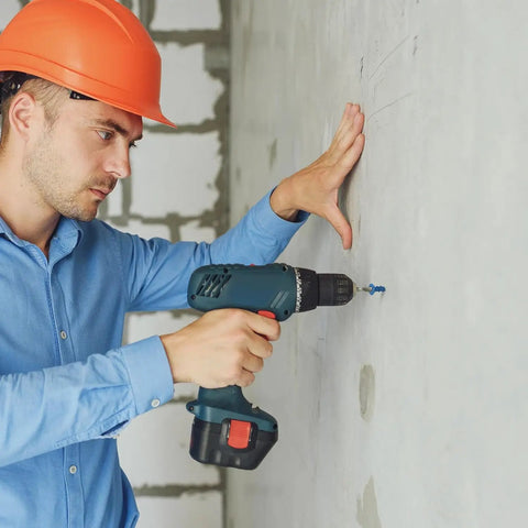 Person using a drill to install 1/4 By 3 1/4 Inch Concrete Screws With Diamond Tail For Fast Drilling into masonry wall.