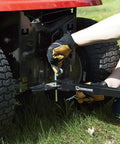 Side view of Acreage Lawn Rake With Four Tine Steel Tow Behind Dethatcher attached to a riding mower, focusing on installation.