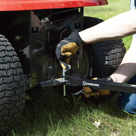 Side view of Acreage Lawn Rake With Four Tine Steel Tow Behind Dethatcher attached to a riding mower, focusing on installation.