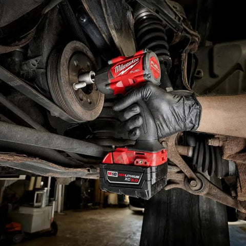 Hard Hitting Brushless Impact Wrench With Friction Ring Unleashes Knockout 1400 Foot Pounds Of Torque For Swift Socket Swaps And Beefy Fastening Tasks Compact 18 Volt Cordless Power Tool Built Like A Tank For Real World Applications in action under a vehicle.