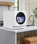 Hella Compact Countertop Dishwasher With Built In Five Liter Tank, white appliance on a kitchen countertop.