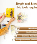 Person using Premium Recloseable Fastener Tape Strips One By Two Inch Clear Heavy Duty Adhesive Pad Ten Pack to hang photos.