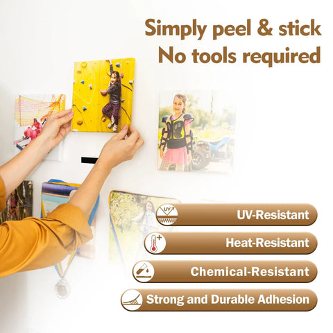 Person using Premium Recloseable Fastener Tape Strips One By Two Inch Clear Heavy Duty Adhesive Pad Ten Pack to hang photos.