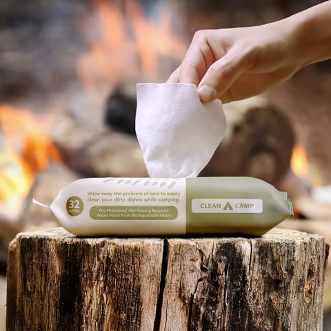 Rinse Free Dish Wipes For Camp Kitchens That Are Biodegradable And Pre Moistened With Food Safe Formula package on a log.