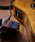Octave Pedal OC-5 For Guitar And Bass With Mono And Poly Modes next to acoustic guitar on wooden floor.