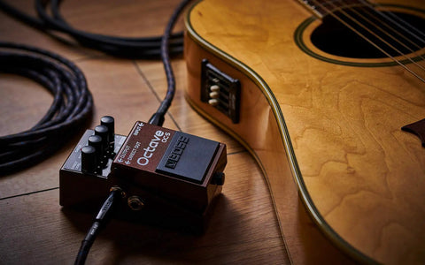 Octave Pedal OC-5 For Guitar And Bass With Mono And Poly Modes next to acoustic guitar on wooden floor.
