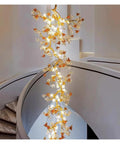 Premium Branch Style Crystal Chandelier With Antique Brass Finish illuminated, hanging in a modern staircase, elegant pendant lamp design.