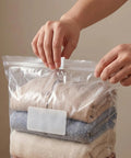 Hands sealing a plastic bag with 40 Pack Vacuum Storage Bag Sealing Clips With Sliding Grip Zipper Bag Sealer Labor Saver For Space Saving