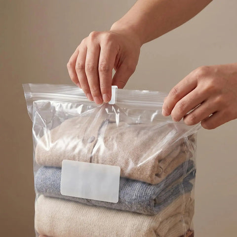 Hands sealing a plastic bag with 40 Pack Vacuum Storage Bag Sealing Clips With Sliding Grip Zipper Bag Sealer Labor Saver For Space Saving