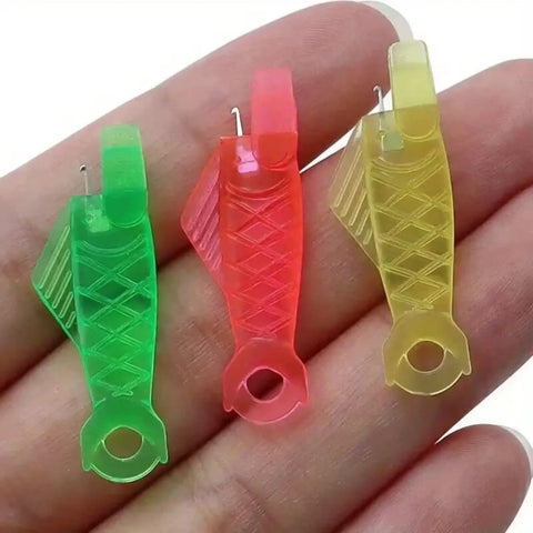 Three fish-type needle threaders on a hand showcasing the Five Piece Fish Type Needle Threaders for Sewing Machines and Hand Sewing.