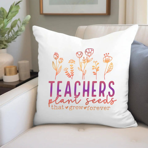 White decorative pillow on couch with floral design and quote "Teachers plant seeds that grow forever" in colorful text.