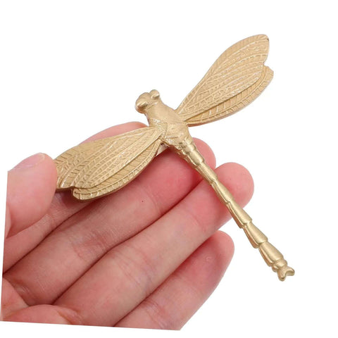 Close-up of Dope Antiqued Brass Dragonfly Cabinet Knobs With Slick Pull Action For Kitchen Cabinets And Drawer Fronts.